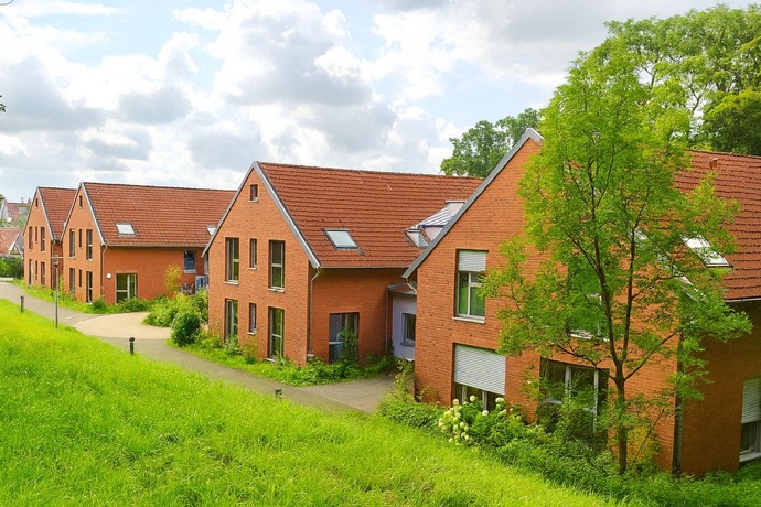 rote Backsteinhäuser auf einer grünen Wiese