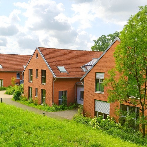 Backsteingebäude hinter grüner Wiese