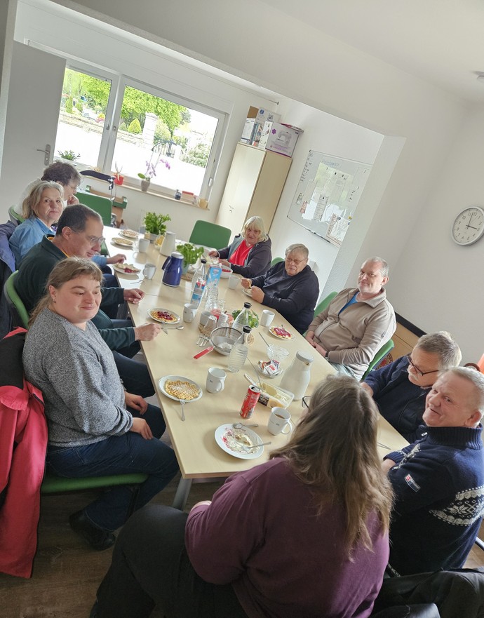 Eine Gruppe sitzt um einen großen Tisch